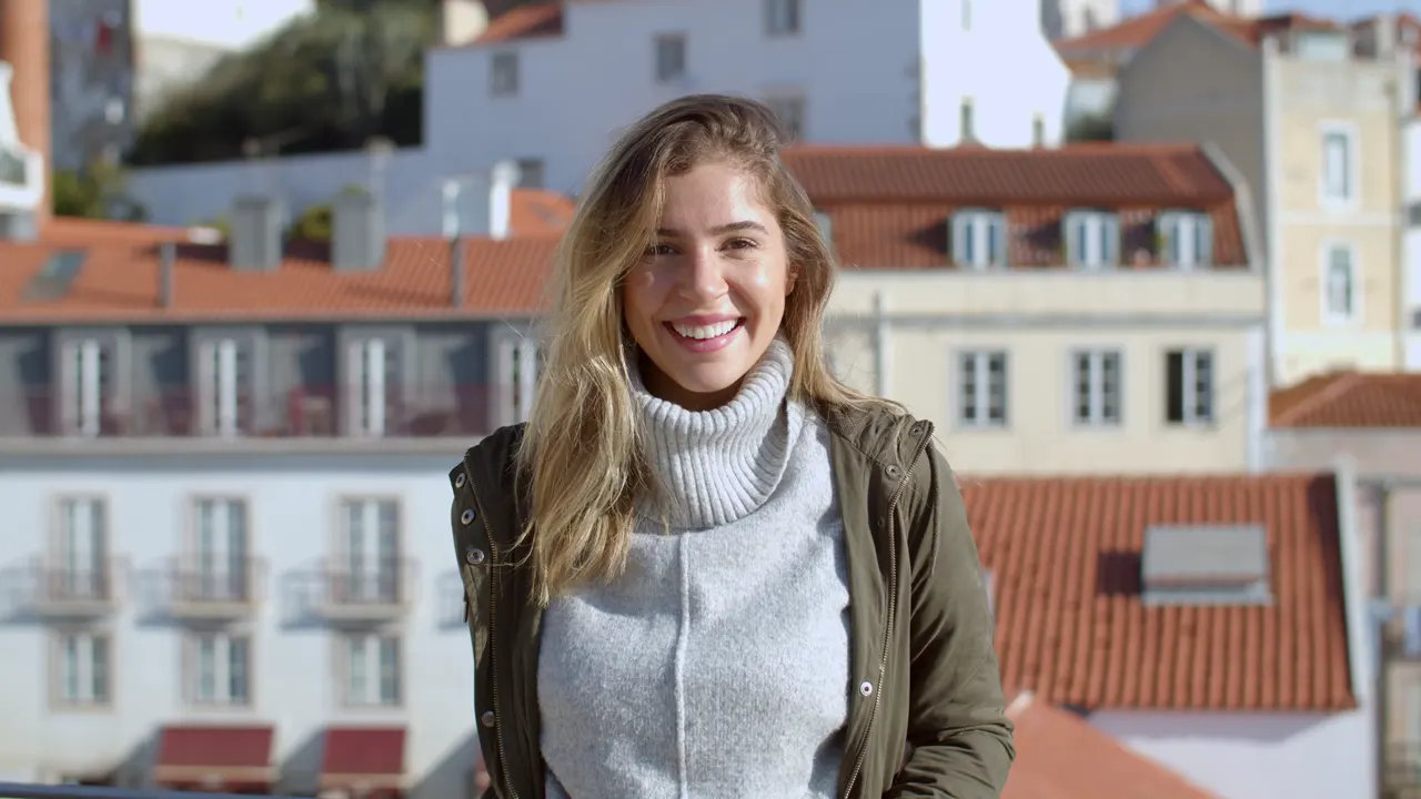 Une voyageuse sourit à la terrasse d’un café
